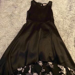 A black high low dress with flowers underneath.